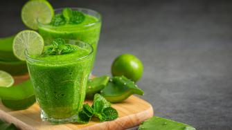 two glasses of aloe vera juice put on wooden cutting board