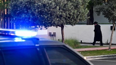 Un coche de la Policía de Miami Beach patrulla cerca de una sinagoga en Florida, tras un tiroteo que dejó dos muertos en Washington, D.C.