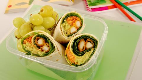 School lunch of fried chicken & avocado wrap sandwich